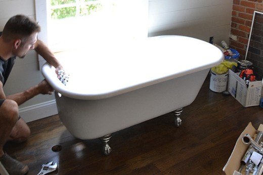 Working on an antique clawfoot tub in a home bathroom