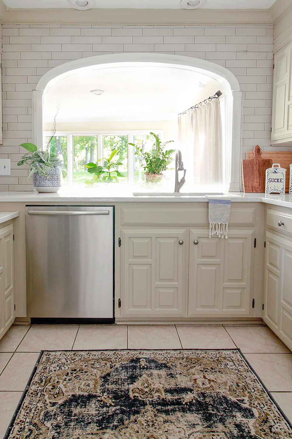 White kitchen with white tile backsplash along archway