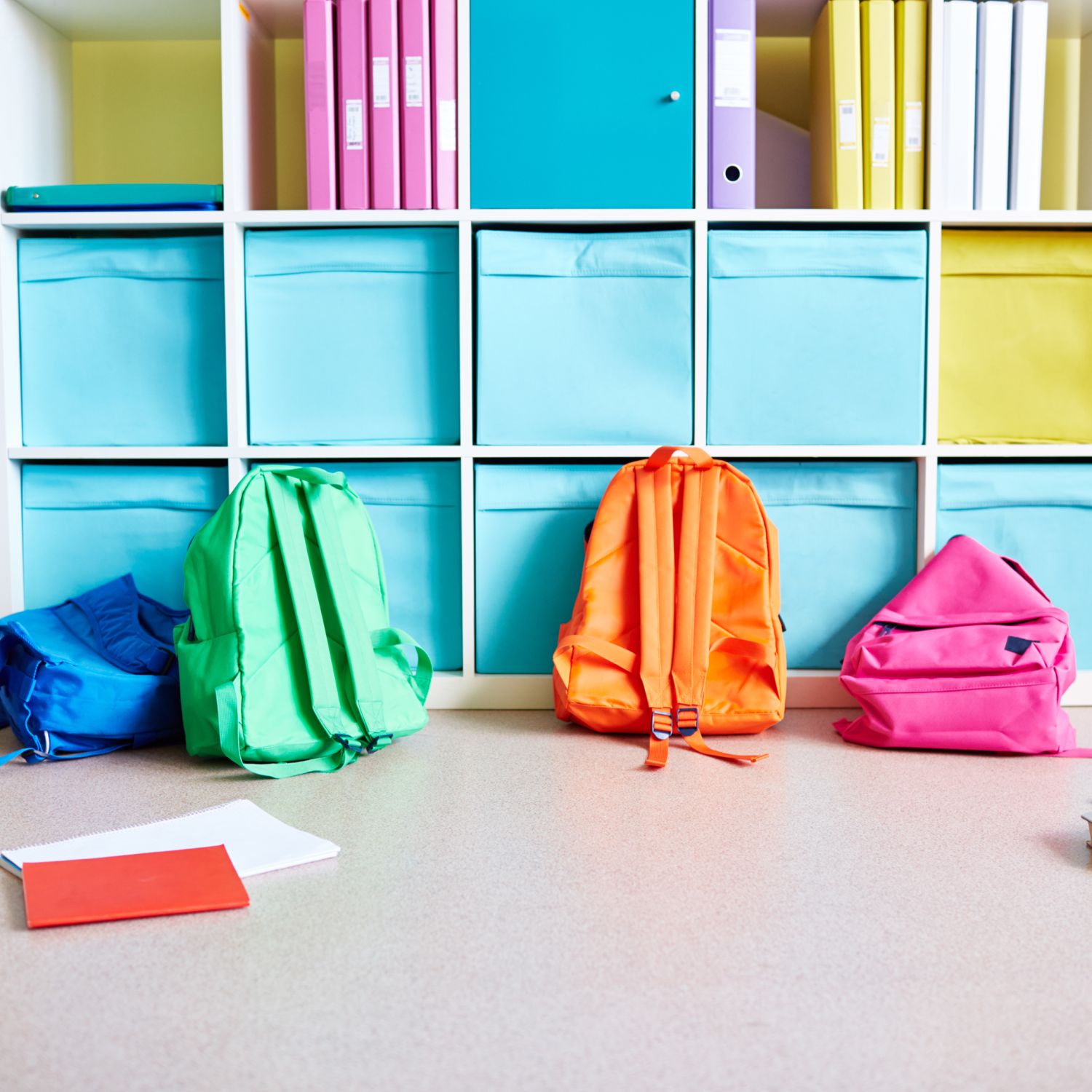 ack to school home organization image of shelves with notebooks and bins and multi colored backpacks