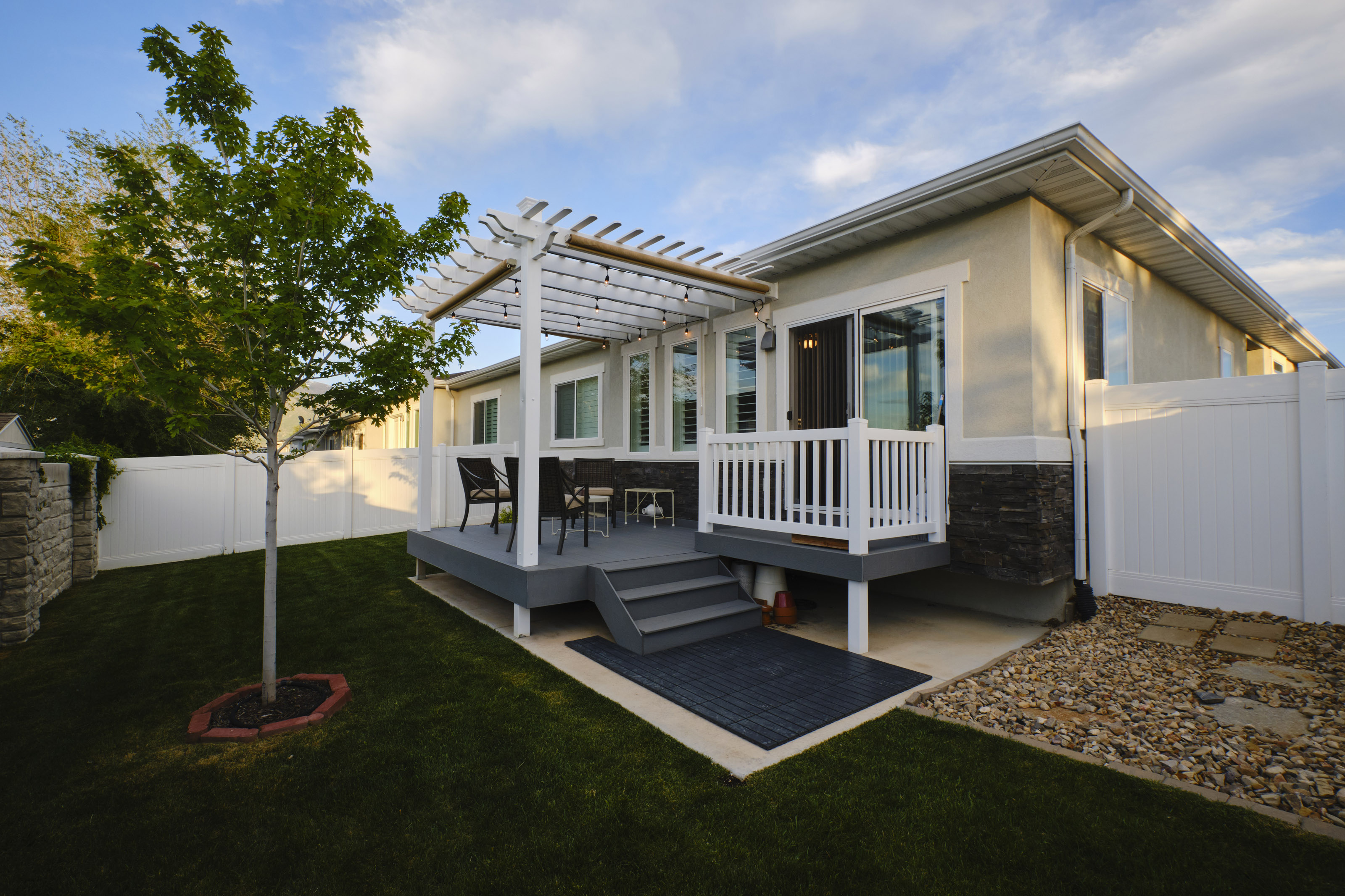 A backyard of a suburban USA home with a deck and pergola.