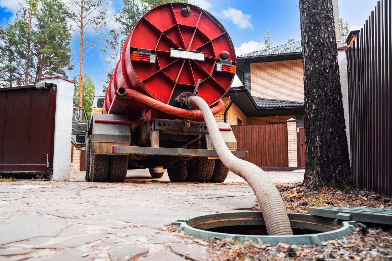 A sewage tank truck pumping out sewage from a septic tank.