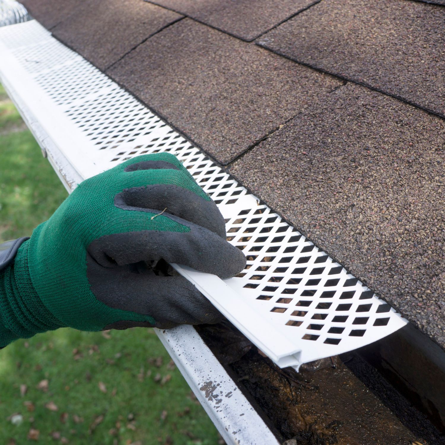 Someone installing plastic gutter guards to get them to fit into place.