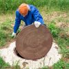 A man checking a plumbing well much like one would for a septic inspection.