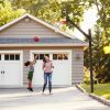 Mother And Children Playing Basketball On Driveway At Home.