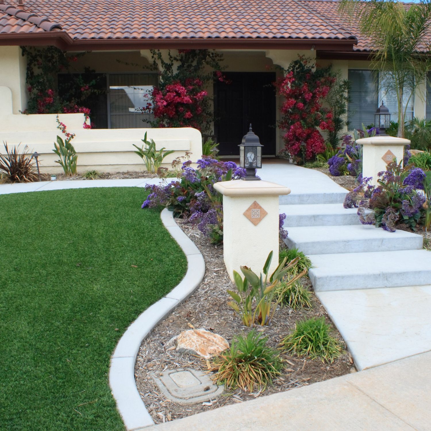 A shot of a gorgeous front yard with artificial grass on either side of a walkway.