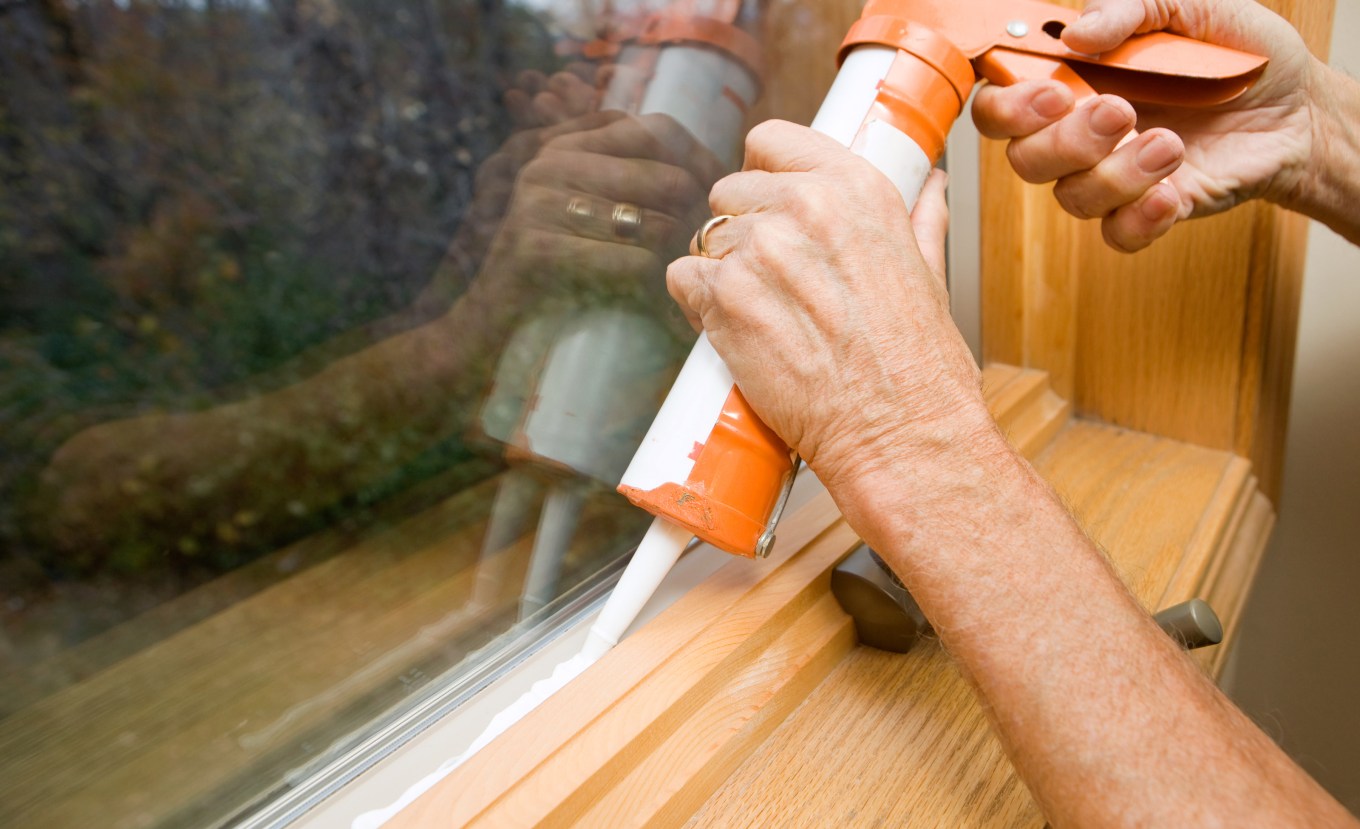 Caulk being applied to a window to improve the seal and weatherproofing.