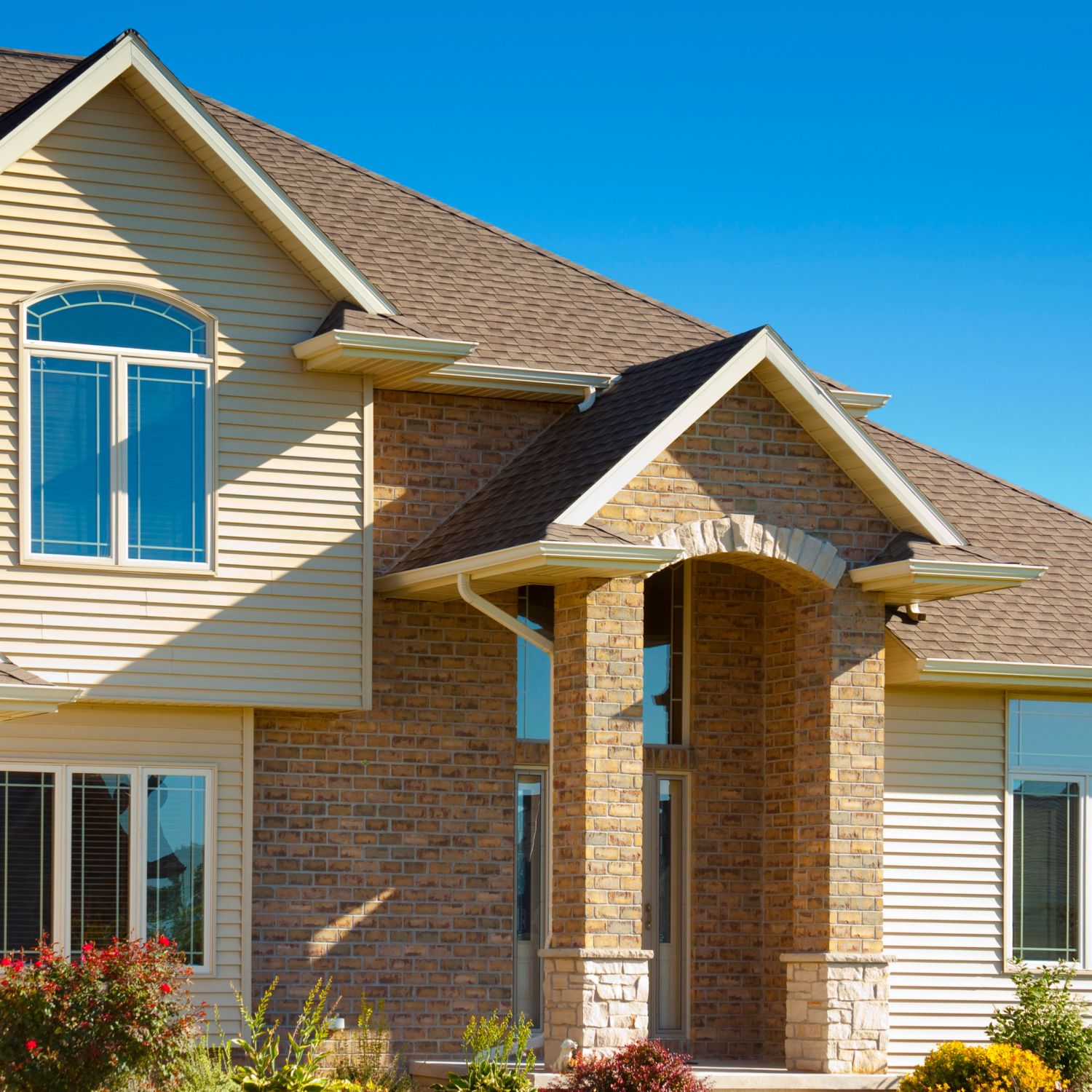 A house with vinyl siding painted and brick.