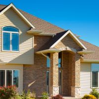 A house with vinyl siding painted and brick.