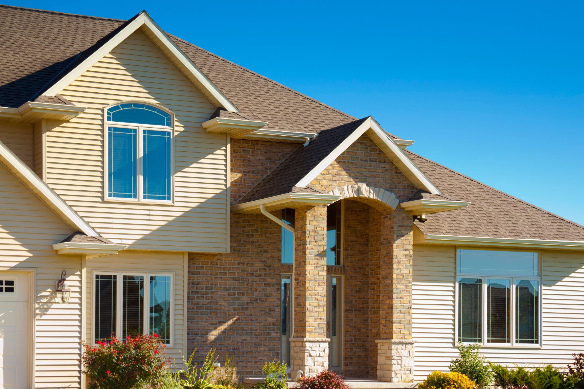 A house with vinyl siding painted and brick.