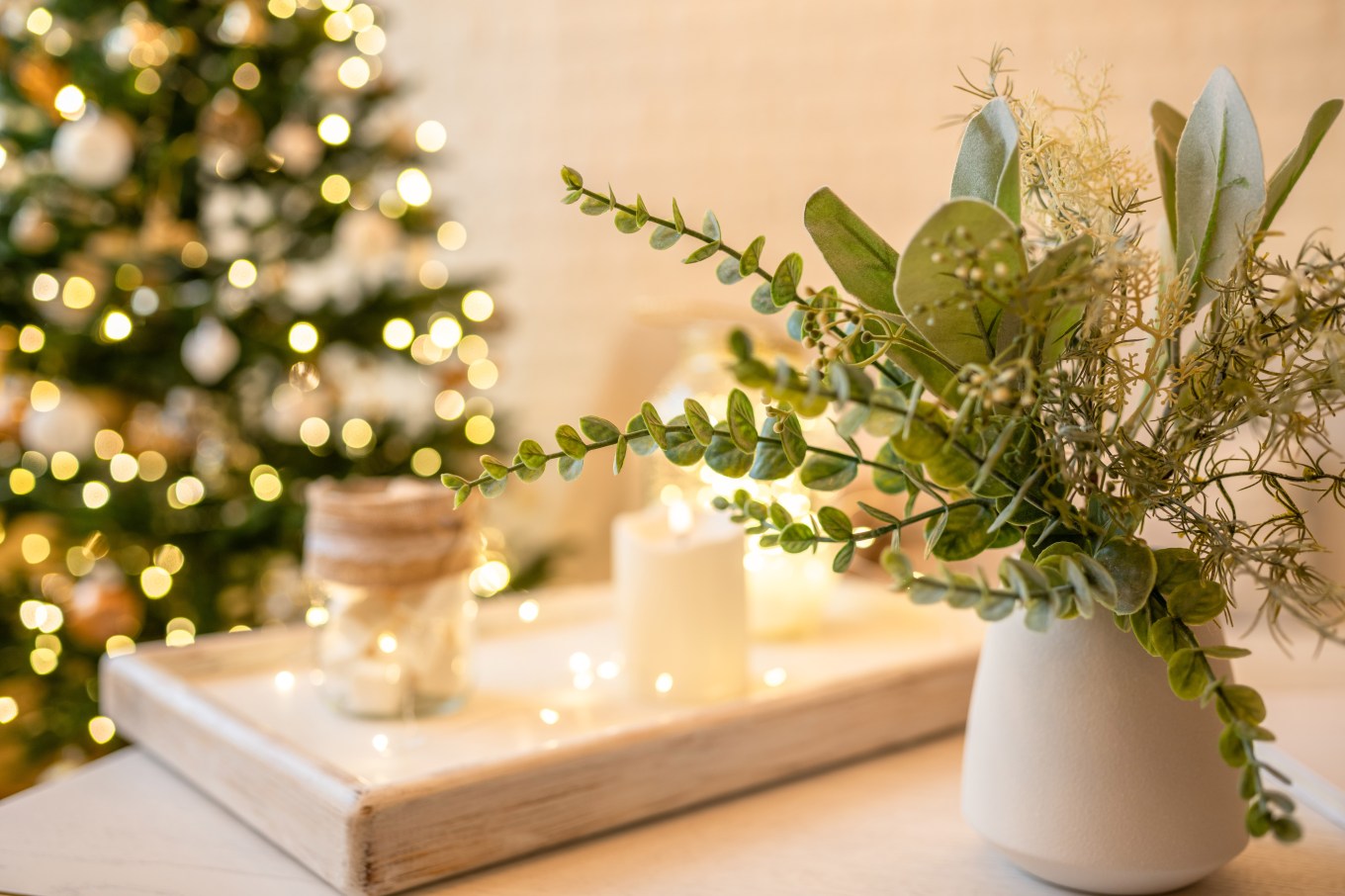 Some beautiful eucalyptus branches accompany a Christmas tree for an example of how one can use holiday plants.