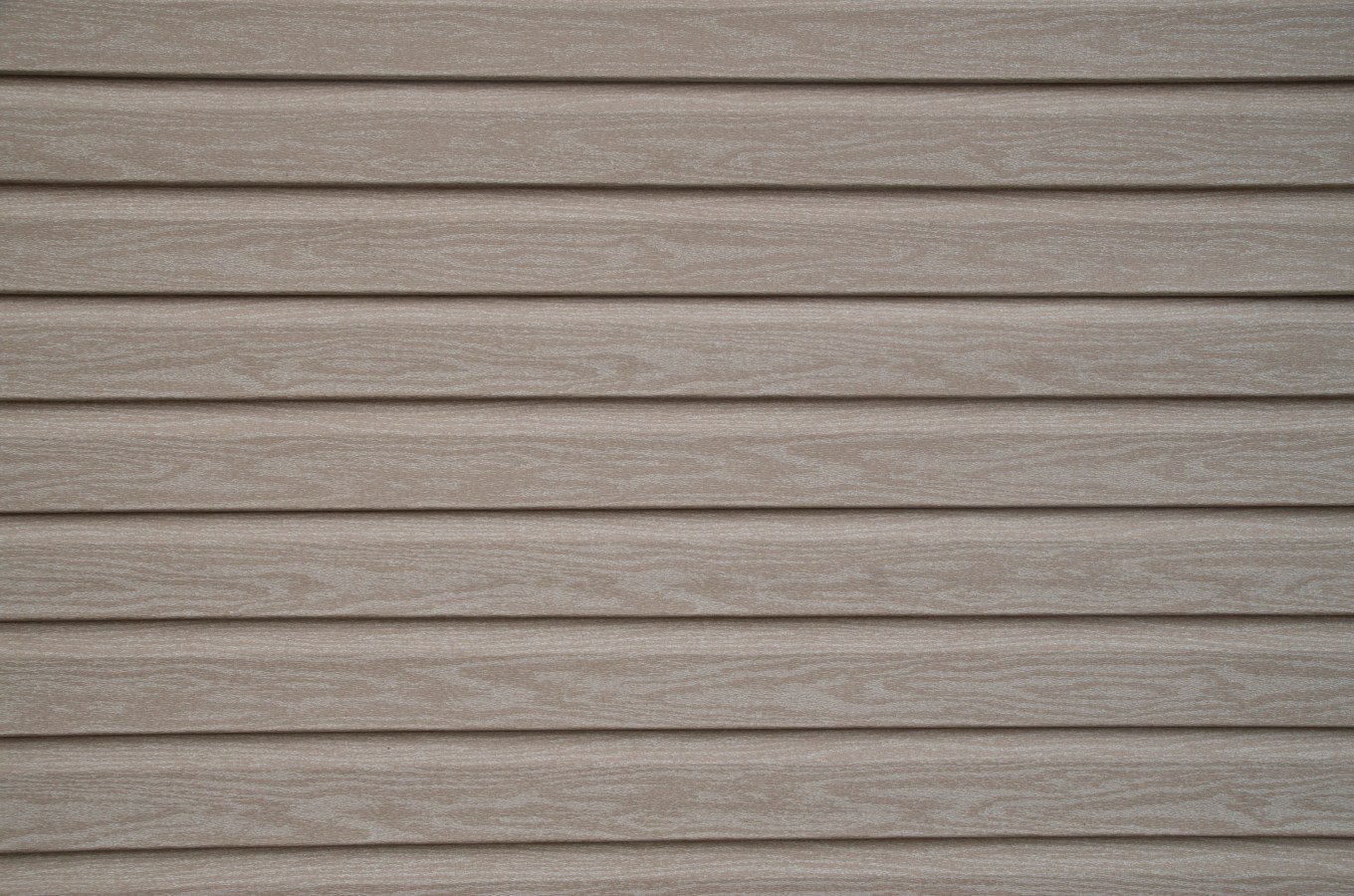 Close up of the texture of engineered wood siding on a house.