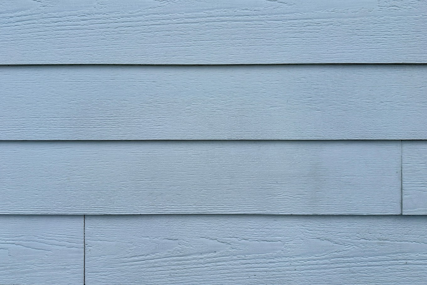 Close up of the texture of fiber cement siding on a house.