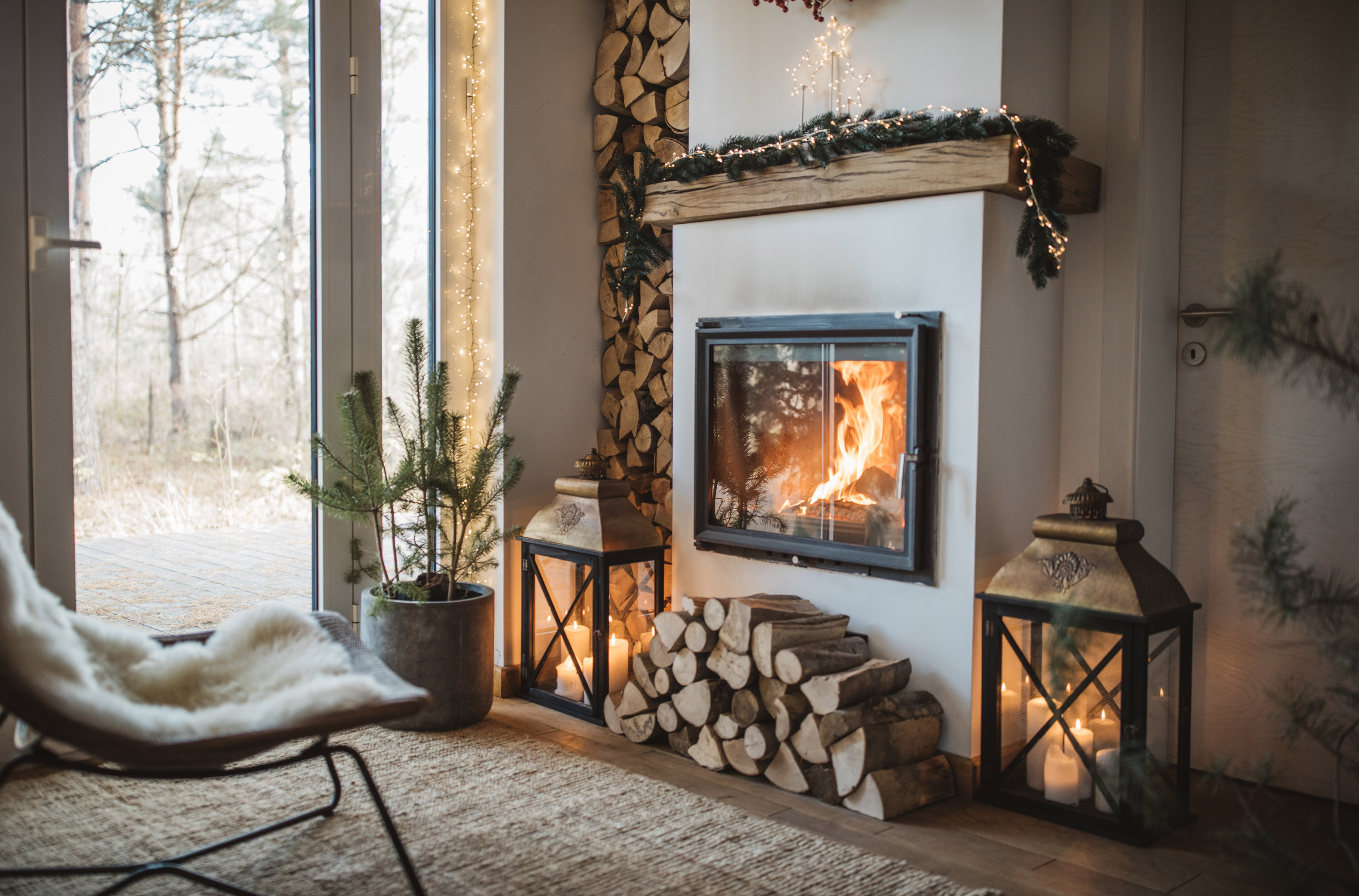 Cozy scandi living room winter interior with wood burning fireplace.