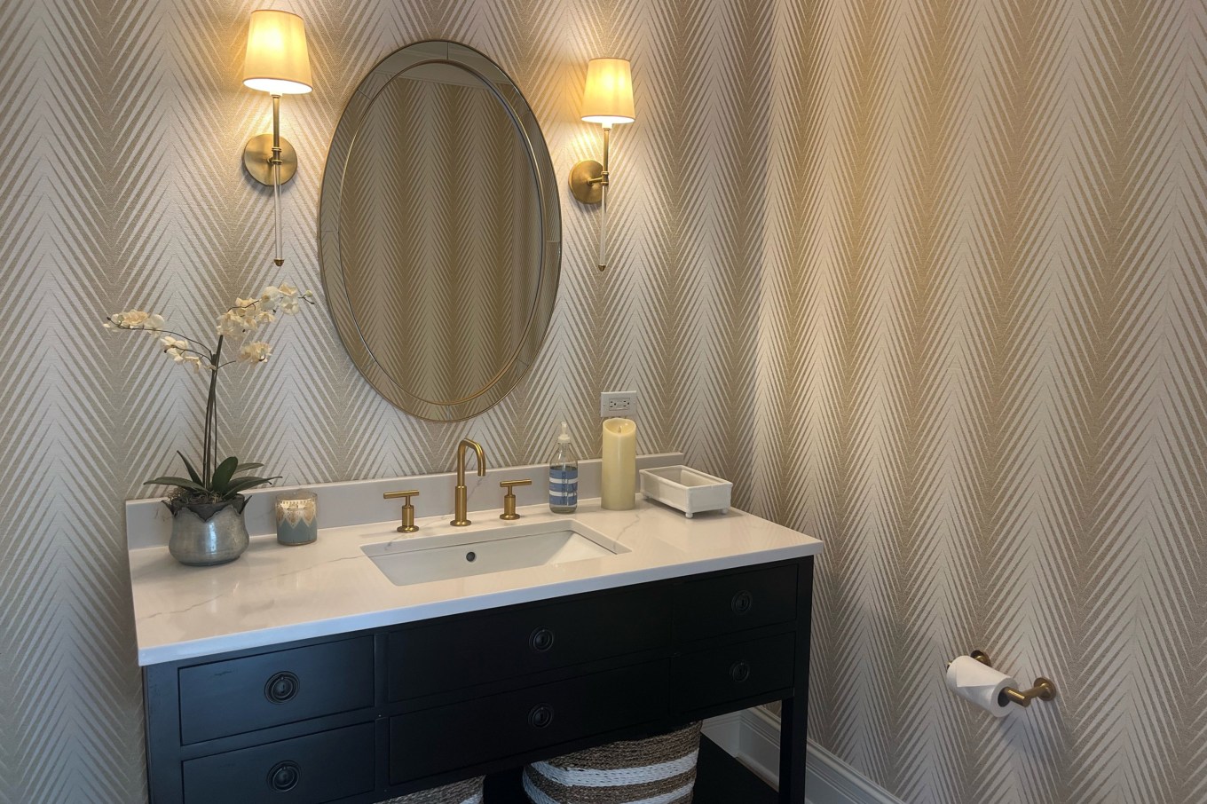 A bathroom with a beautiful sink in front of wallpaper signaling a 2025 home trend.