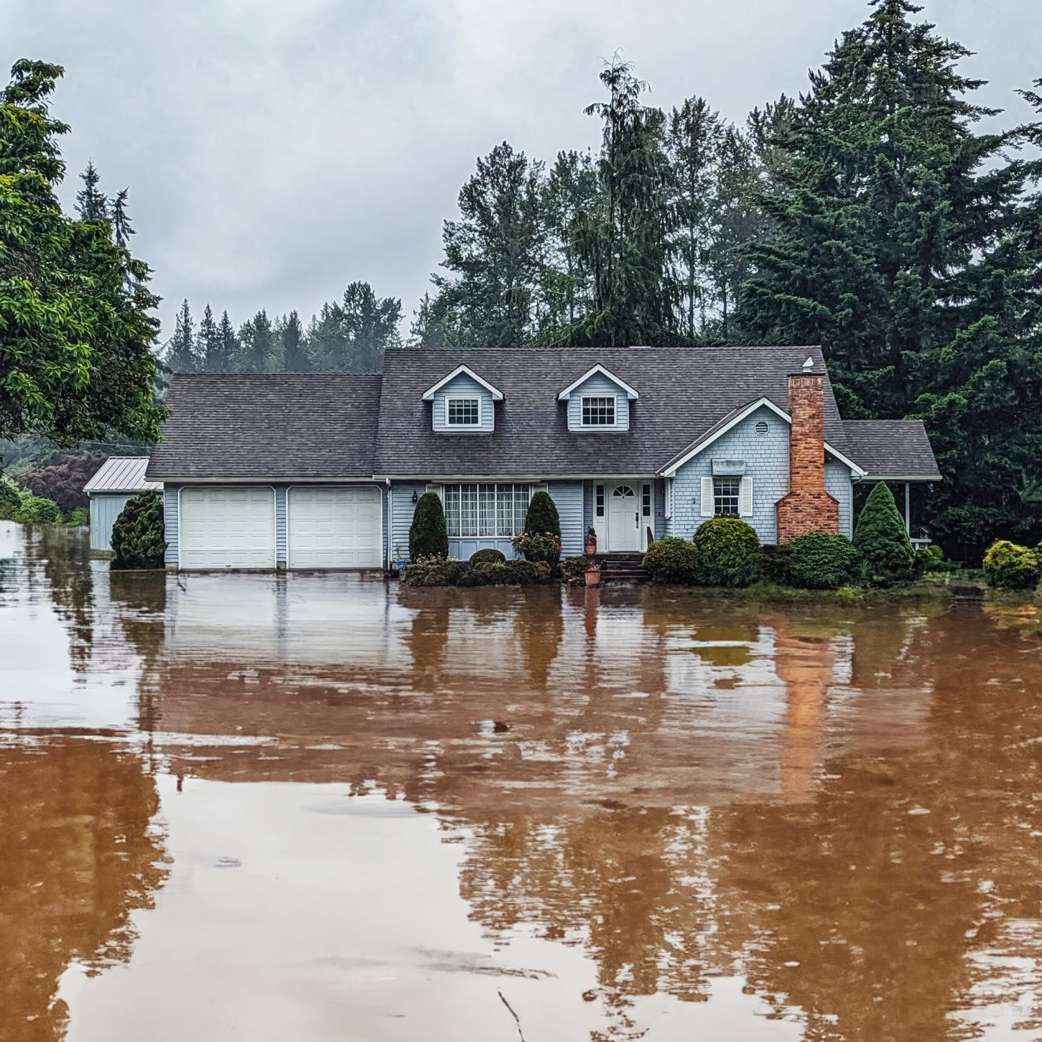 Photo of house exterior with flooded yard.