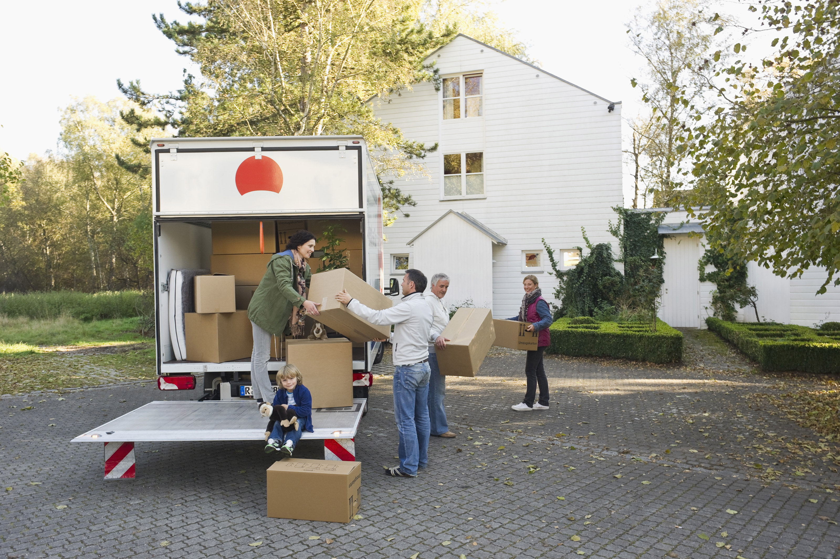 A multigenerational family unpacking boxes to move into a new home.