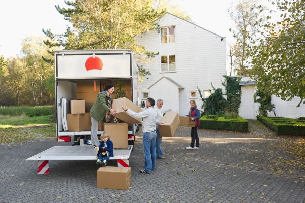 A multigenerational family unpacking boxes to move into a new home.