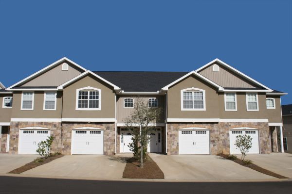 Newly constructed townhouse-style homes on clear sunny day.