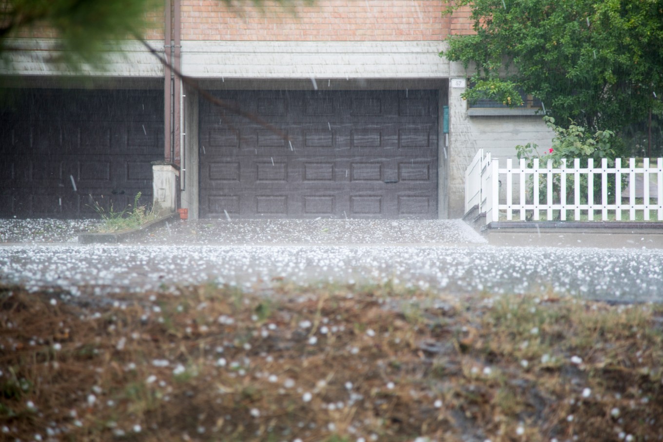 Hail pelting the garage of townhomes causing damage.