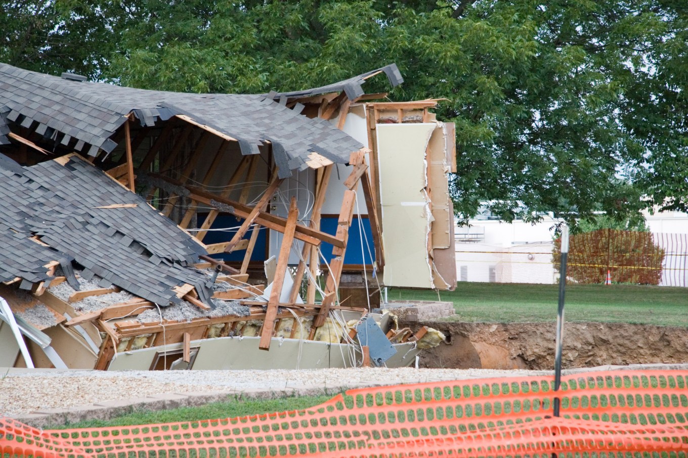 A house falling into a 75 foot wide sinkhole that is slowly expanding.